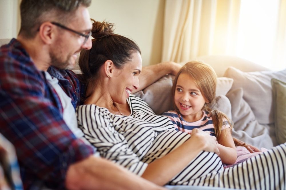 Expecting mom relaxing on the couch with her family
